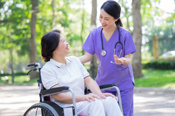 Asian female nurse taking care of a middle-aged female patient in the park