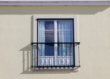 Large Window With Metal Railing Outside. Window With French Balcony On Yellow Wall.