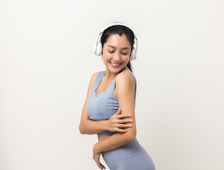 Wall Mural - Sexy sporty fitness asian woman with sportswear put on headphone isolated white background. Portrait Good shape and healthy woman standing pose exercise workout in studio.