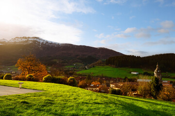 Wall Mural - sunrise shine on green grass field at public park at the hill near city in valley. beautiful landsca