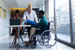 © Wavebreak Media - African american businesswoman on call by albino male colleague talking to businessman on wheelchair