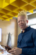 © Wavebreak Media - Portrait of smiling african american mid adult albino businessman with digital tablet in office