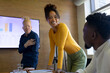 © Wavebreak Media - African american businesswoman and albino businessman looking at male colleague in conference room