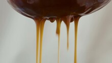 Close-up Of Liquid Caramel Sauce Flowing Through A Sieve
