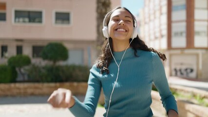 Poster - young african american woman listening to music and dancing at street