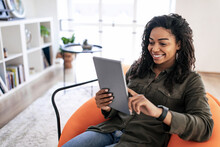 Portrait Of Smiling Black Woman Using Digital Tablet At Home