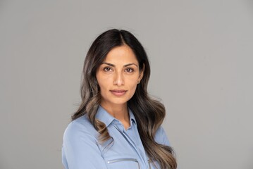 Studio headshot of beautiful Asian Indian woman in blue blouse.