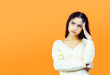 Tired and fed up concept with beautiful brunette woman on orange background with copy space.
