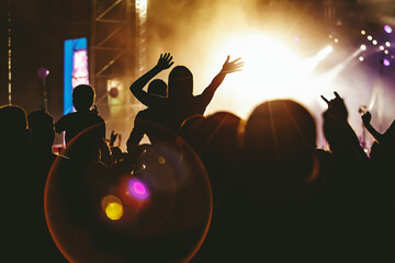 People dancing and having fun at summer festival party outdoor - Crowd with hands up celebrating concert event.