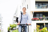 Fototapeta Na drzwi - Junge blonde Frau fährt Fahrrad in einer Stadt