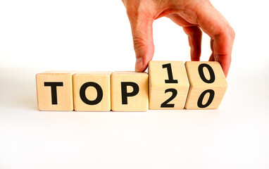 From Top 20 to 10 symbol. Businessman turns wooden cubes and changes concept words Top 20 to Top 10. Beautiful white table white background. Business and from Top 20 to Top 10 concept. Copy space.