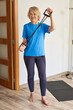 © JENOCHE - mature woman doing sports at home with a rubber band