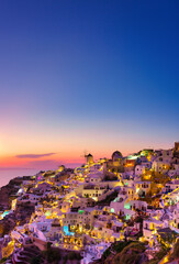 Wall Mural - Oia village, Santorini, Greece. View of traditional houses in Santorini. Small narrow streets and rooftops of houses, churches and hotels. Landscape during sunset.