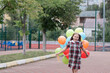 © OliaVesna - charming teenage girl in checkered brown dress with bunch of colorful balloons. school girl. pretty tween