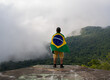 Young Man at Mountain Looking to Horizon in Nature with brazilian Flag.