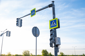 Pillar with two traffic lights. The traffic lights don't work. Road signs. Crosswalk