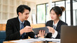 © bongkarn - Professional Asian male financial consultant discussing with a female client.