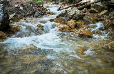 Wall Mural - Cascade of waterfalls among stones. Fluffy water. Spring landscape. Falling water.