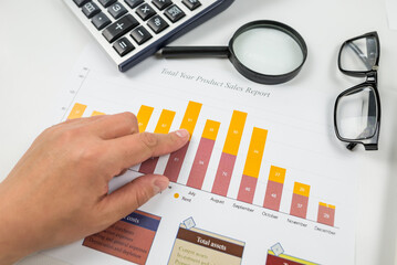 Close-up of a woman's hand pointing at a chart.