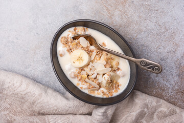 Wall Mural - Healthy breakfast of granola with fresh banana, nuts and yogurt