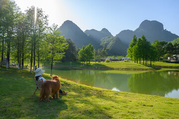 Wall Mural - Golden Retriever accompanies its owner by the lake