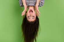 Portrait Of Upside Down Impressed Cheerful Lady Open Mouth Look Camera Isolated On Green Color Background