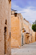 Typical Street With An Ancient Buildings In Mdina, Malta Island. Mdina Is A Fortified City In The Northern Region Of Malta Which Served As The Island's Capital From Antiquity To The Medieval Period.