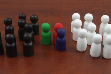 Redd, green and blue people figures between two groups of white and black figures. Moderation concept.	