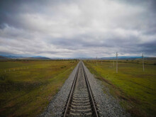 Straight Single Train Track Leading In The Vast Tundra Of Siberia On The Trans Siberian Railway.