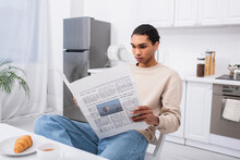 African American Man Reading Newspaper Near Breakfast On Table.