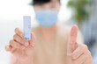 © Tom Wang - Woman showing thumbs up and antigen self test card with negative result for  Covid-19