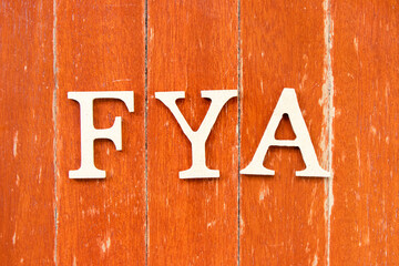 Sticker - Alphabet letter in word FYA (Abbreviation of For your action or attention) on old red color wood plate background