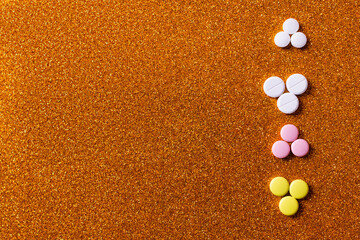 Wall Mural - top view of row with different colorful pills on shiny background.