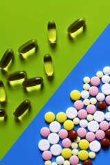 Wall Mural - top view of different colorful pills and jelly capsules on bright blue and green background.