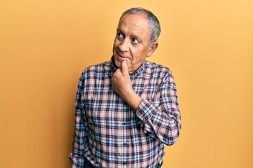 Poster - Handsome senior man with grey hair wearing casual shirt with hand on chin thinking about question, pensive expression. smiling with thoughtful face. doubt concept.