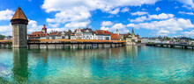 Panoramic View Of Lucerne (Luzern) Town With Famous Chapel Wooden Bridge Over Reuss River.  Switzerland Travel And Landmarks.