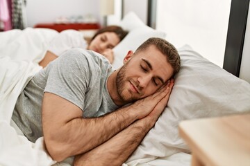 Poster - Young caucasian couple sleeping on bed at home.