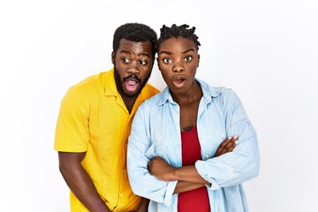 Poster - Young african american couple wearing casual clothes afraid and shocked with surprise expression, fear and excited face.