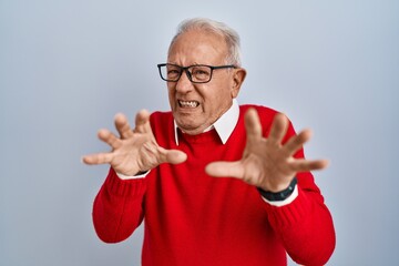 Poster - Senior man with grey hair standing over isolated background afraid and terrified with fear expression stop gesture with hands, shouting in shock. panic concept.