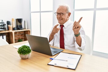 Poster - Senior man working at the office using computer laptop pointing aside worried and nervous with both hands, concerned and surprised expression