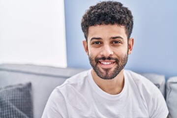 Canvas Print - Young arab man smiling confident sitting on sofa at home