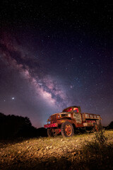 Canvas Print - Beautiful shot of an old car under the milky way sky