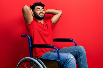 Canvas Print - Arab man with beard sitting on wheelchair relaxing and stretching, arms and hands behind head and neck smiling happy