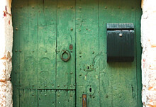 Close-up Of An Old Wooden Green Door With A Black Mailbox Of A Fisherman's House
