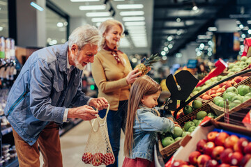 Wall Mural - Cute little girl shopping with grandparents