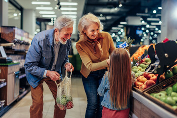 Wall Mural - Girl, grandfather and grandmother in grocery store