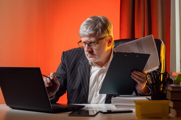 Poster - the businessman is working hard. a man with gadgets and documents. a person works on a laptop. the l