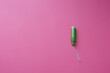 Green tampon with plastic applicator on pink background, flat lay with copy space, female hygiene, menstruation or women period, monthly bleeding, gynecology and healthcare, feminine blog template