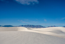 Rolling Sand Dunes And San Andres Mountains Sit Under A Partially Cloudy Sky