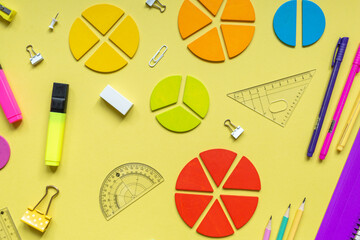 Wall Mural - Multicolored fractions, rulers, pencils, notepad on yellow background. Interesting, fun math for kids. Education, back to school concept	